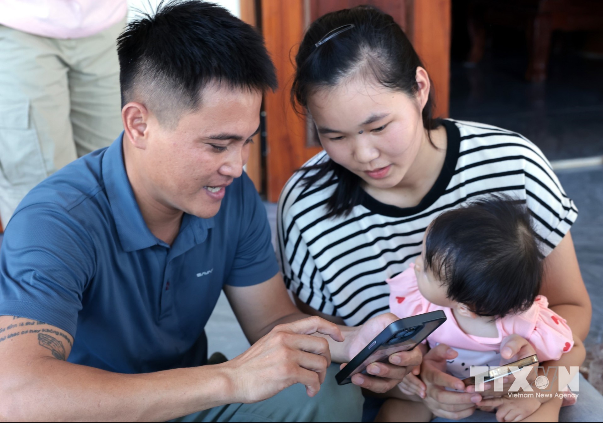 Trợ giúp người dân cài đặt và khai thác, sử dụng thông tin trên ứng dụng Quangtri - S và các ứng dụng khác. (Ảnh: Trần Việt/TTXVN)